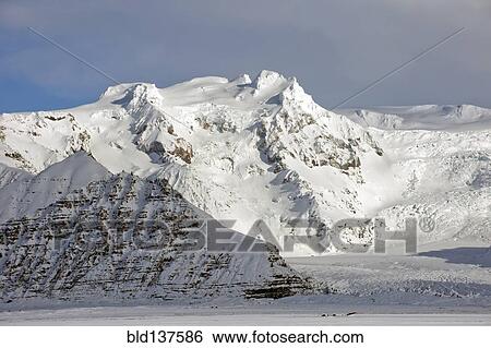 Stock Photograph - Iceberg looming over arctic landscape. Fotosearch