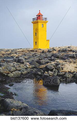 Stock Image - Lighthouse overlooking rocky landscape. Fotosearch