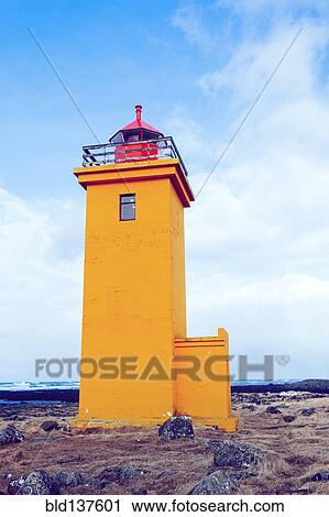 Stock Image - Lighthouse overlooking rocky landscape. Fotosearch