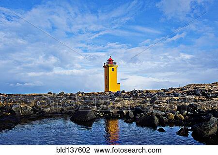 Stock Image - Lighthouse overlooking rocky landscape. Fotosearch