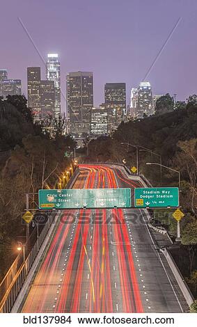 Picture - Los Angeles city skyline over busy highway illuminated at night, California, United States. Fotosearch