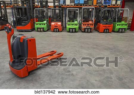 Mechanical dolly and forklift machinery in warehouse View Large Photo Image Stock Image - Mechanical dolly and forklift machinery in warehouse. Fotosearch