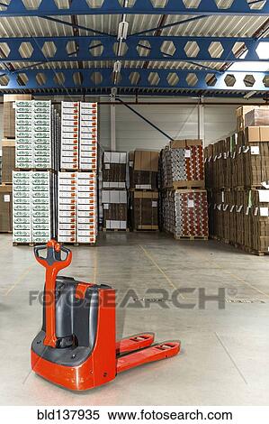 Stock Photography - Mechanical dolly with pallets in warehouse. Fotosearch