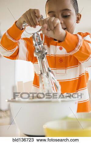 Mixed race boy baking in kitchen View Large Photo Image Stock Image - Mixed race boy baking in kitchen. Fotosearch