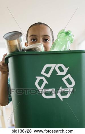 Mixed race boy carrying recycling View Large Photo Image Stock Photo - Mixed race boy carrying recycling. Fotosearch