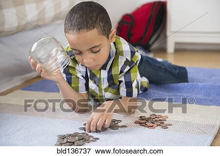Stock Photo - Mixed race boy counting change on floor. Fotosearch