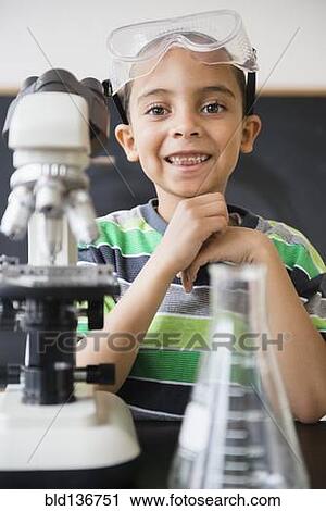 Stock Image - Mixed race boy doing experiments in science class. Fotosearch