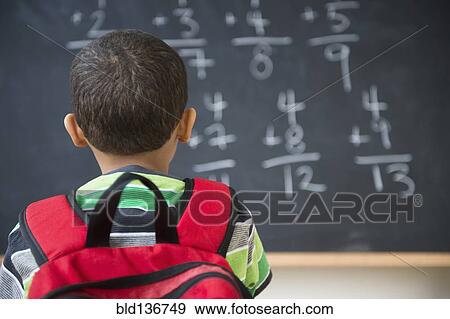 Stock Photo - Mixed race boy doing math problems at board in class. Fotosearch
