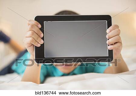Picture - Mixed race boy holding tablet computer. Fotosearch