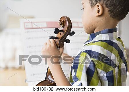 Stock Image - Mixed race boy holding violin. Fotosearch