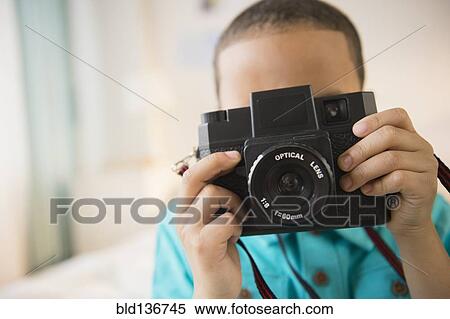 Stock Photography - Mixed race boy taking pictures. Fotosearch