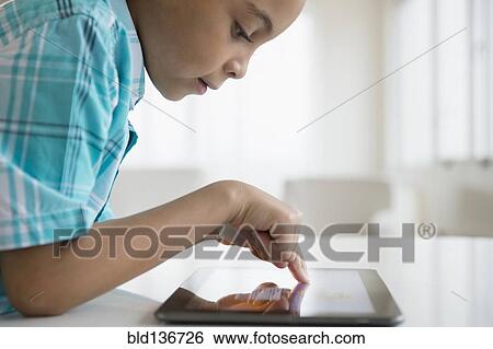 Mixed race boy using tablet computer View Large Photo Image Stock Photograph - Mixed race boy using tablet computer. Fotosearch