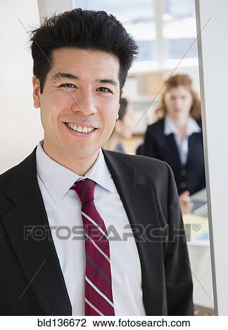 Stock Image - Mixed race businessman smiling in office. Fotosearch
