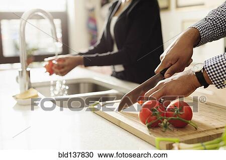 Mixed race couple cooking together in kitchen View Large Photo Image Stock Image - Mixed race couple cooking together in kitchen. Fotosearch