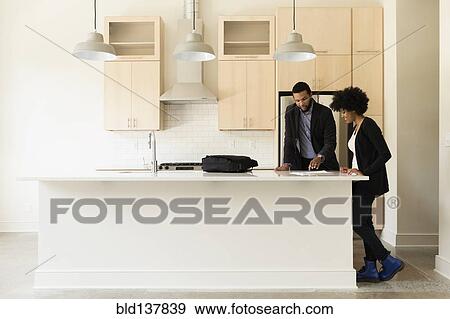 Mixed race couple reading paperwork in new house View Large Photo Image Stock Photo - Mixed race couple reading paperwork in new house. Fotosearch