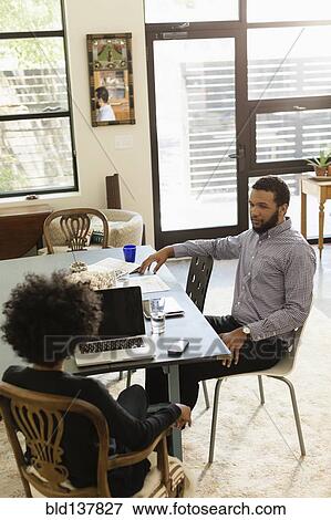 Mixed race couple talking at breakfast table View Large Photo Image Stock Photo - Mixed race couple talking at breakfast table. Fotosearch