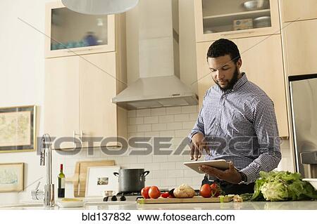 Mixed race man cooking with tablet computer in kitchen View Large Photo Image Stock Image - Mixed race man cooking with tablet computer in kitchen. Fotosearch