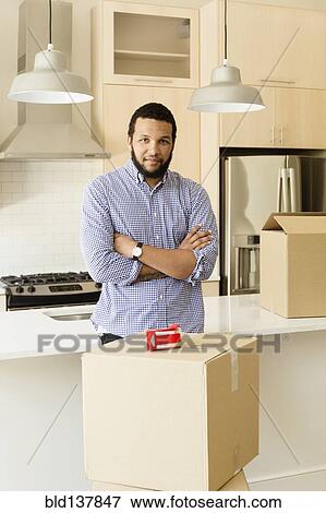 Mixed race man standing in new house View Large Photo Image Stock Photo - Mixed race man standing in new house. Fotosearch