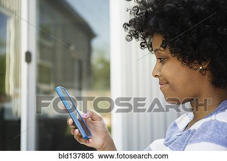 Mixed race woman using cell phone outdoors View Large Photo Image Stock Photography - Mixed race woman using cell phone outdoors. Fotosearch
