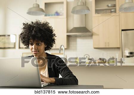 Mixed race woman using laptop at breakfast table View Large Photo Image Stock Photography - Mixed race woman using laptop at breakfast table. Fotosearch