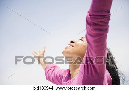 Mixed race woman with arms outstretched outdoors View Large Photo Image Picture - Mixed race woman with arms outstretched outdoors. Fotosearch