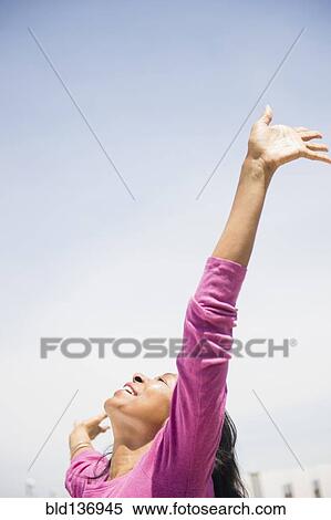 Stock Photography - Mixed race woman with arms outstretched outdoors. Fotosearch