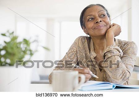 Mixed race woman writing at desk View Large Photo Image Stock Image - Mixed race woman writing at desk. Fotosearch