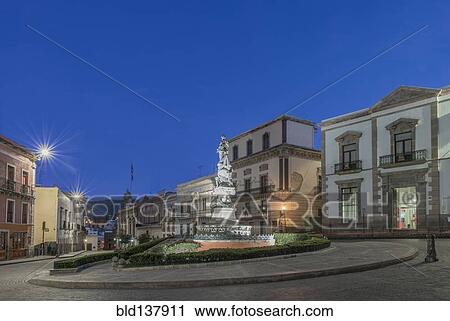 Stock Image - Monument in Plaza de la Paz lit up at night, Guanajuato, Guanajuato, Mexico. Fotosearch