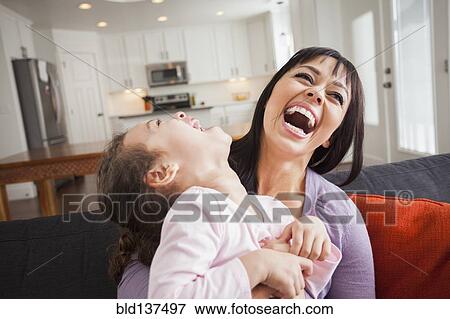 Stock Photo - Mother and daughter playing on sofa. Fotosearch