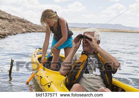 Stock Image - Older Caucasian man in kayak with granddaughter. Fotosearch