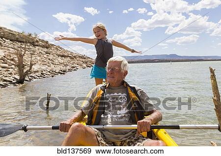 Stock Photo - Older Caucasian man rowing kayak with granddaughter. Fotosearch