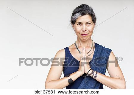 Stock Image - Older Hispanic woman with hands clasped. Fotosearch