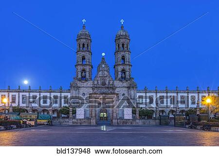 Stock Photo - Ornate church overlooking town square at dusk, Zapapan, Jalisco, Mexico. Fotosearch