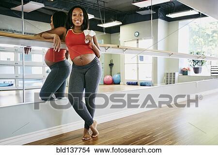 Picture - Pregnant Black woman smiling in yoga studio. Fotosearch