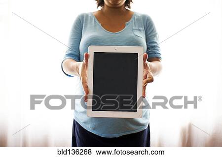 Pregnant Hispanic woman holding tablet computer View Large Photo Image Stock Photo - Pregnant Hispanic woman holding tablet computer. Fotosearch