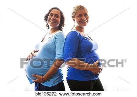 Stock Image - Pregnant women holding their bellies. Fotosearch
