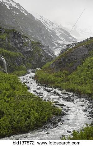 Stock Image - Rocky river flowing through snow covered mountains, Anchorage, Alaska, Denali National Park, United States. Fotosearch