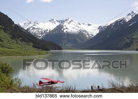 Stock Photography - Seaplane docked in still lake in mountain landscape, Anchorage, Alaska, Denali National Park, United States. Fotosearch