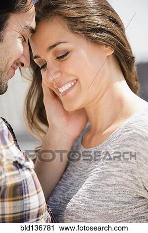 Stock Image - Smiling man caressing face of woman. Fotosearch