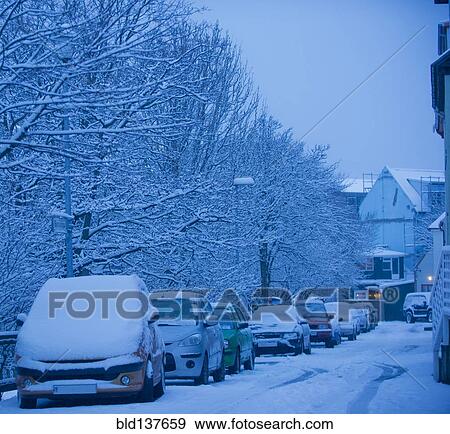 Stock Photo - Snow covered cars parked on city street. Fotosearch