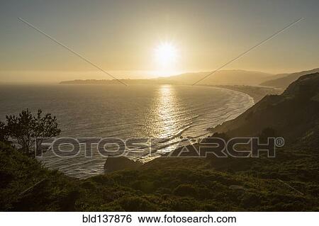 Stock Photograph - Sun setting over coastal landscape, Stinson Beach, California, United States. Fotosearch