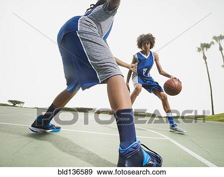 Teenage boys playing basketball on court View Large Photo Image Stock Photo - Teenage boys playing basketball on court. Fotosearch