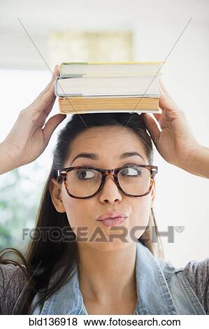 Stock Photo - Woman balancing stack of books on her head. Fotosearch
