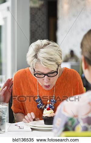 Stock Photography - Woman celebrating birthday in restaurant. Fotosearch