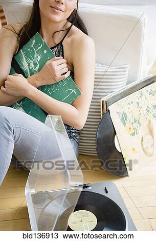 Woman holding vinyl records in living room View Large Photo Image Stock Image - Woman holding vinyl records in living room. Fotosearch