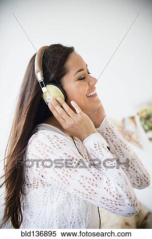 Stock Photography - Woman listening to headphones. Fotosearch
