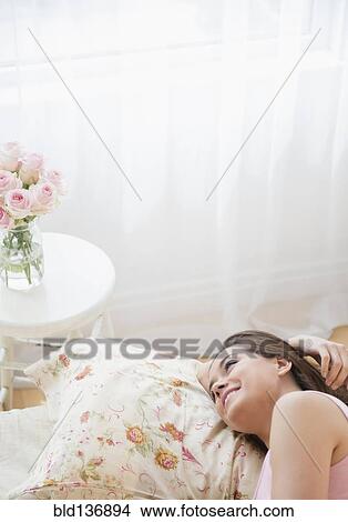 Picture - Woman relaxing on bed. Fotosearch