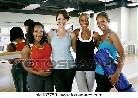 Stock Photo - Women smiling together in yoga studio. Fotosearch