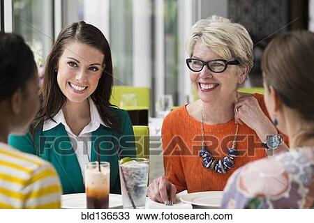 Stock Image - Women talking in restaurant. Fotosearch