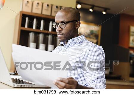 Black man using laptop in coffee shop View Large Photo Image Stock Photo - Black man using laptop in coffee shop. Fotosearch